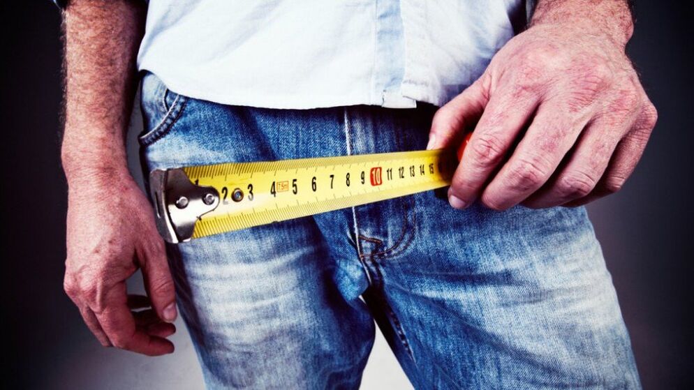 Mann moosst Penis no der Erweiderung mat Gel